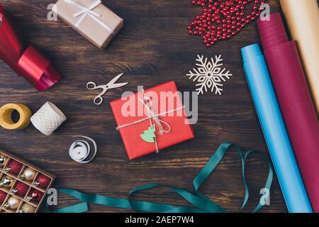 Collection of newyear things concept. Above high angle close up photo of small packed giftbox surrounded by handicraft stuff different wrapping paper Stock Photo