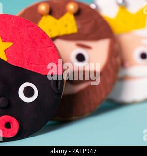 closeup of some homemade cookies in the shape of the three wise men on a blue background Stock Photo