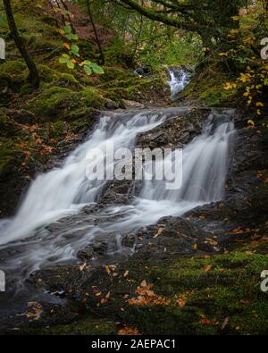 Tranquil autumn woodland scene.Waterfall in Scottish highlands on beautiful, sunny day.Motion of flowing water.Fairytale seasonal landscape image.