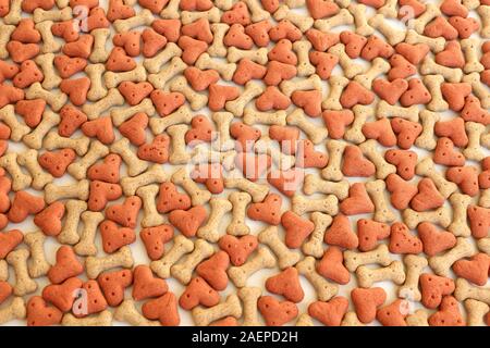 Bone and heart shaped dog biscuits. Dog treat background. Stock Photo