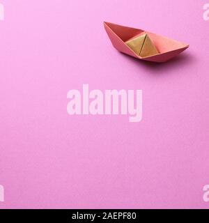 Paper ship on pink background Stock Photo