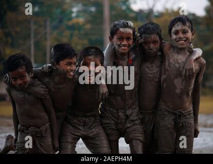 Some kids who are playing on mud ground Stock Photo