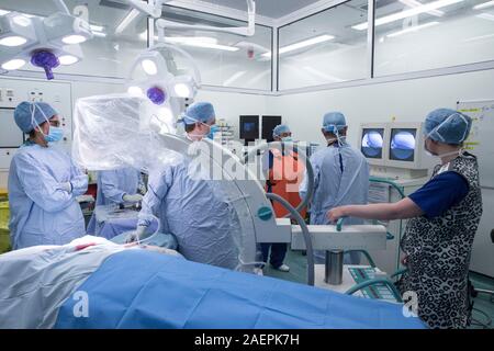 Surgeons at an NHS Hospital perform a knee operation, known as an Arthroplasty, to repair the damaged joint with an artificial one. Stock Photo