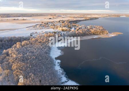 Aerial drone view of a lake coast starting to freeze over in winter sunrise light. Tartu, Estonia. Stock Photo