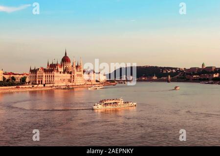 BUDAPEST, HUNGARY JULY 29, 2019: Beautiful evening view on Hungarian Parliament Building along Danube River with cruise ships on natural background. T Stock Photo