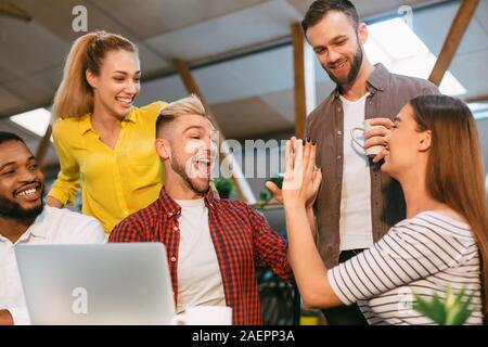 Success. Young colleagues giving high five and smiling Stock Photo
