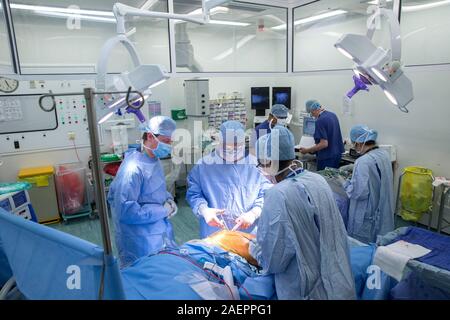 Surgeons at an NHS Hospital perform a knee operation, known as an Arthroplasty, to repair the damaged joint with an artificial one. Stock Photo