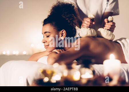 Beautiful woman having Thai herb compress massage Stock Photo
