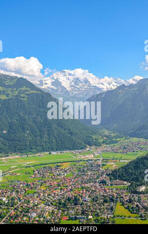 Amazing view of Interlaken and adjacent mountains photographed from the top of Harder Kulm in Switzerland. Swiss Alps landscape. City in the Alpine valley surrounded by mountains. Vertical photo. Stock Photo