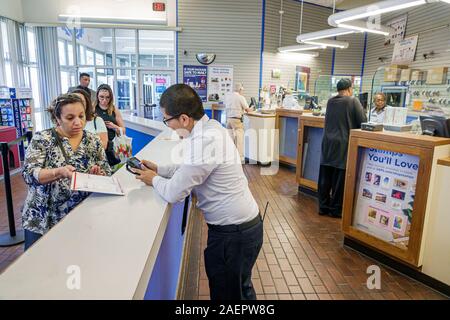 Orlando Florida,Lake Buena Vista USPS,Post Office mail inside counter postal worker,employee customer Hispanic man woman line queue handheld scanner Stock Photo