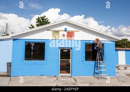 Indiantown Florida,commercial one-story building,Hispanic Latin Latino ethnic immigrant immigrants minority,man men male adult adults,painting painter Stock Photo