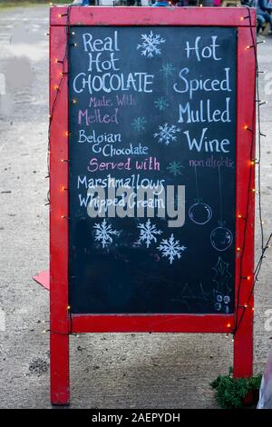 Hot chocolate on a cold December day. A sign advertising hot chocolate and hot mulled wine. Stock Photo