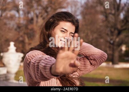 Young girl reaches forward to camera, laughing. Stock Photo