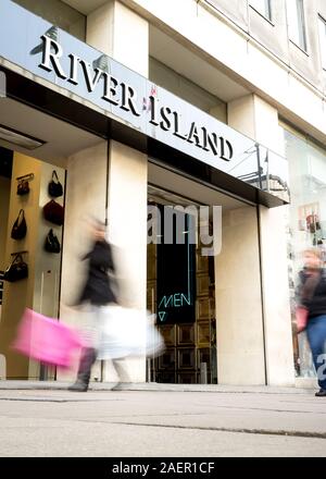 LONDON, UK - 23 NOVEMBER 2011: Blurred shoppers walking past the River Island store, a fashion retailer, on London's Oxford Street. Stock Photo