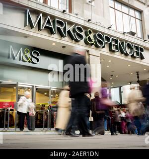 LONDON, UK - 23 NOVEMBER 2011: Marks & Spencer. Anonymous shoppers walking past the flagship M&S store in London's Oxford Street shopping district. Stock Photo