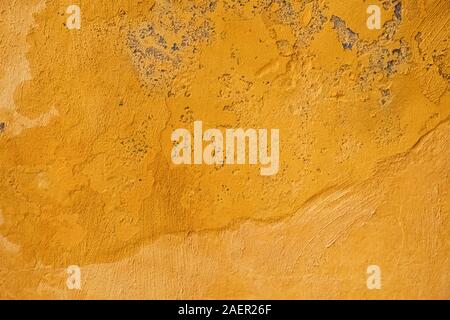 Rough concrete wall painted in yellow color. Stock Photo
