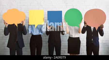 Group of corporate people hiding faces behind speech bubbles Stock Photo