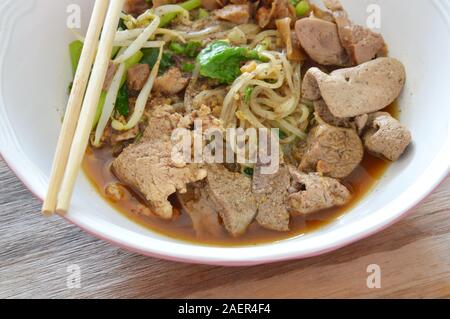 thin rice noodle topping braised pork and liver in brown soup Stock Photo