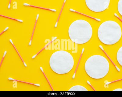 Cotton pads and swabs isolated on yellow background. Horizontal image, flat lay, top view from above Stock Photo
