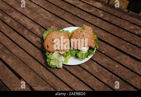 Sandwich with Hum and salad on a wooden bench Stock Photo