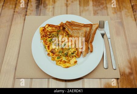Omelet with vegetables and bread toast on white a plate Stock Photo