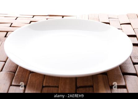 Isolated white plate on a wooden stand Stock Photo