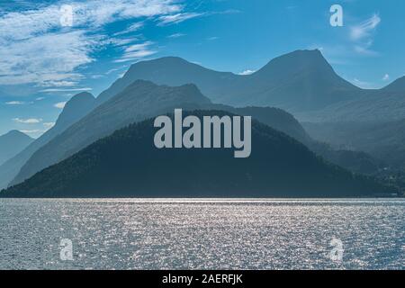 Norddalsfjord, view from the Linge ferry terminal to the south, backlit mountain ranges, near Eidsdal, More og Romsdal, Norway Stock Photo