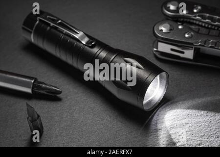 black flashlight on the stone surface. Tools for work, search and tourism .. Stock Photo