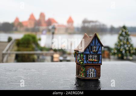 Small terracotta house on a table with castle on the background, Trakai, Vilnius, Lithuania Stock Photo