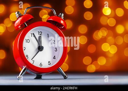 alarm clock on blurry lights background. Before the new year 5 minutes.. Stock Photo