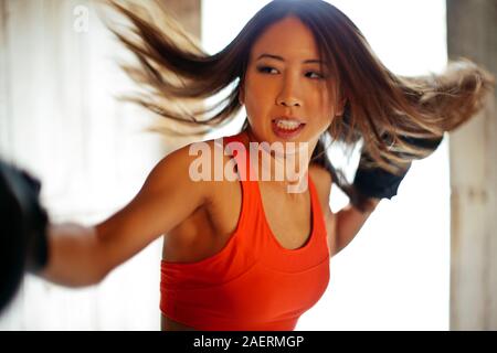 Tough young woman practices boxing. Stock Photo