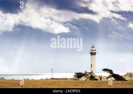 Pigeon Point Lighthouse on the Pacific Ocean coastline; sun rays bursting through storm clouds; Pescadero, San Francisco bay area, California Stock Photo