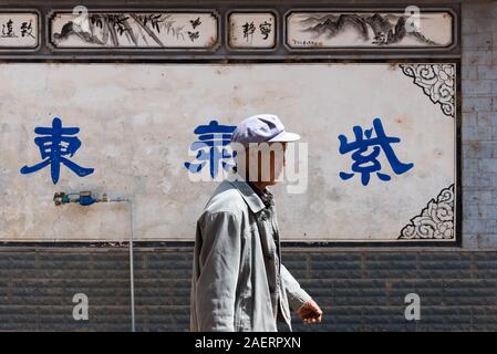 March 13, 2019: Some Elderly Bai ethnic minority man walking in Zhoucheng village, Yunnan, China Stock Photo
