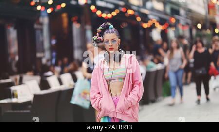 Urban portrait of eccentric young woman model on the streets - Unique-looking younger with colourful hair, accessories and clothes Stock Photo