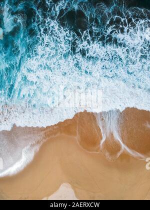 Aerial drone shot of deep blue waves crashing on sandy beach Mexico Stock Photo