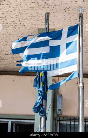 Greek national flag, shredded by the wind, behind it flag of the European Union, hangs, Stock Photo