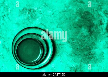 Different Ceramic Empty Green Plates on Grey Background, Top View, Copy Space, trendy green toned image Stock Photo