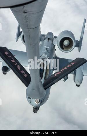 A KC-135 Stratotanker assigned to the Utah Air National Guard’s 151st Air Refueling Wing refuels an A-10 Thunderbolt || assigned to the 190th Fighter Squadron, over Southwest Idaho, Dec. 7, 2019. The Idaho and Utah Air National Guard units collaborated to support an in-flight refueling experience for spouses of Airmen from the 124th Fighter Wing. (U.S. Air National Guard photo by Airman 1st Class Taylor Walker) Stock Photo