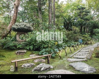 Japanese garden, moss, bamboo curved fence, tobi-ishi stepping stone pathway, Garyusanso, Ozu, Ehime, Shikoku, Japan Stock Photo