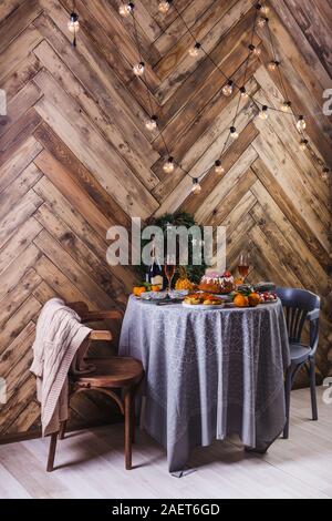 Beautiful served table with decorations, candles and lanterns. Living room decorated with lights. Stock Photo