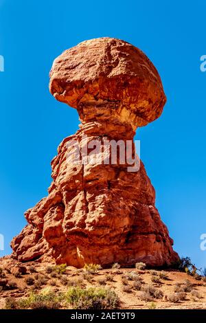 Balanced Rock, a tall and delicate sandstone Rock Formation in the desert landscape of Arches National Park near Moab in Utah, United States Stock Photo