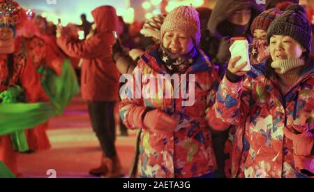 Peope dance at the Snow Carnival at the China Snow Town in Mudanjiang city, north-east China's Heilongjiang province, 27 November 2019.   To attract m Stock Photo