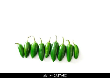 A row of bright green jalapeno peppers isolated on a white background with copy space; food preparation Stock Photo