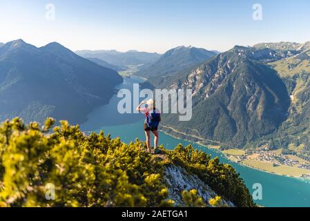 Young hiker, woman looking into the distance, view from Baerenkopf mountain to Lake Achen, left Seebergspitze and Seekarspitze, right Rofan Stock Photo