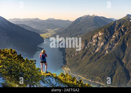 Young hiker, woman looking into the distance, view from Baerenkopf mountain to Lake Achen, left Seebergspitze and Seekarspitze, right Rofan Stock Photo