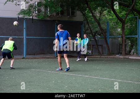 Street domestic playing soccer. Young guys play soccer on a green grass Stock Photo