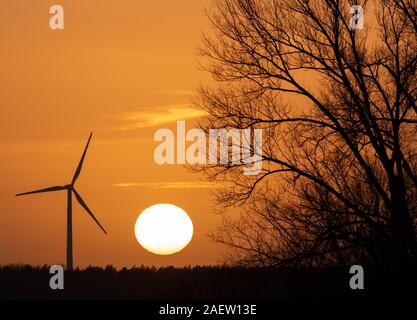 10 December 2019, Brandenburg, Bernau /Ot Birkholzaue: The sun goes down behind a windmill. Photo: Soeren Stache/dpa-Zentralbild/dpa Stock Photo