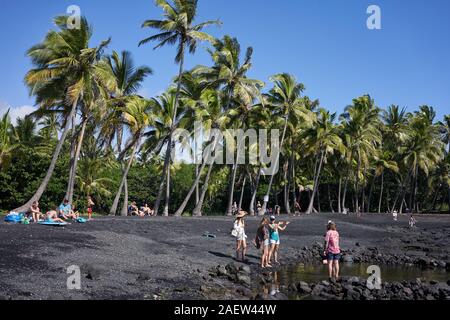 Visitors at the Punalu'u Black Sand Beach, a beach between Pāhala and Nāʻālehu on the Big Island, Hawaii, on Thursday, Nov 28, 2019. Stock Photo