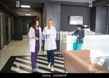 Two female doctors walking in the clinic corridor Stock Photo