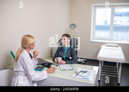 Two women having a conversation in a light room Stock Photo